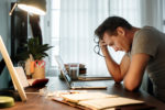 man sitting at his desk overwhelmed from stress