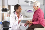 Doctor Discussing Records With Senior Female Patient